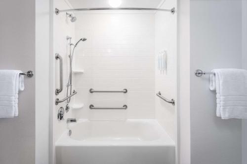 a white bathroom with a tub and a shower at Best Western Premier - The Tides in Orange Beach