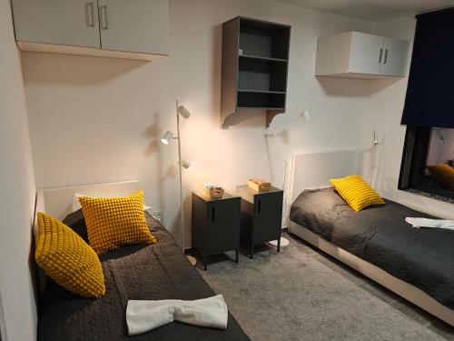 a bedroom with two beds with yellow pillows at Southern Sun in Tilburg