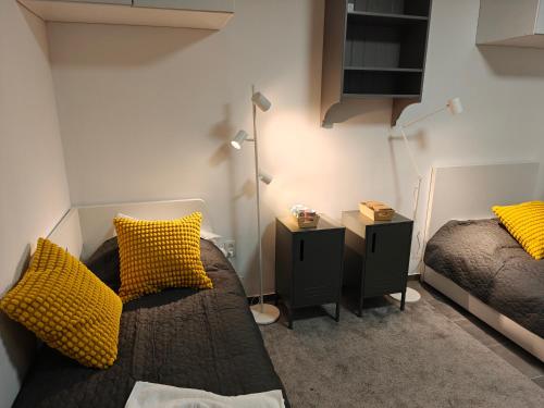 a bedroom with two beds with yellow pillows at Southern Sun in Tilburg