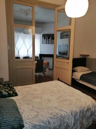 une chambre avec un lit et un bureau avec une télévision dans l'établissement Une balade à la plage, à Dunkerque