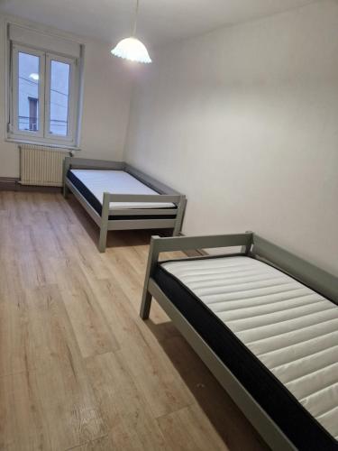 deux lits dans une chambre avec parquet dans l'établissement La ferme 1313 jusqu'à 8 personnes, à Cirey-sur-Vezouse