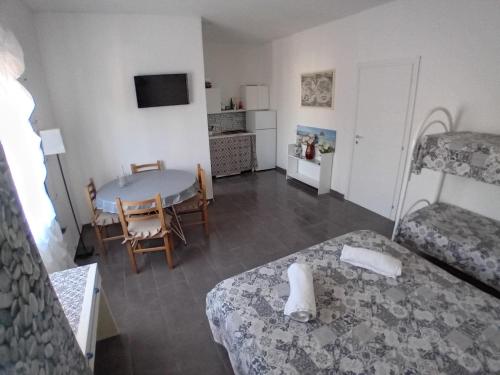a room with a table and a bed and a room with a table and chairs at bbsulmare-com Sole Apartment in Porto Empedocle