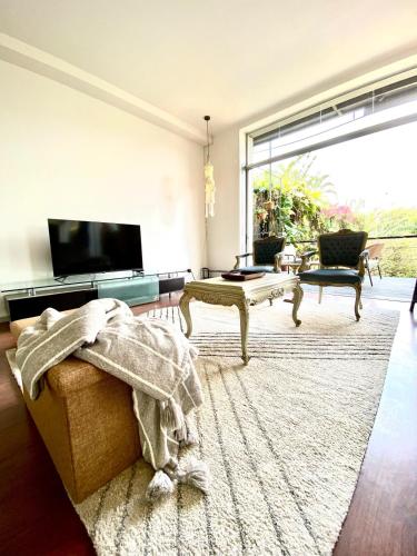 Ciudad Cariariにあるvilla country club cariariのソファと大きな窓のあるリビングルーム