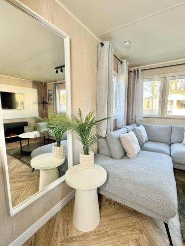 a living room with a blue couch and two tables at Miarlo Lodge Derwent Haven Lakeland in Grange Over Sands