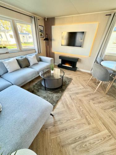 a living room with a couch and a tv at Miarlo Lodge Derwent Haven Lakeland in Grange Over Sands