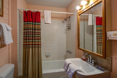 a bathroom with a sink and a tub and a shower at Angel Fire Cabin in Angel Fire