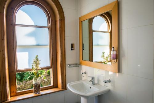a bathroom with a sink and two windows at Regent Hotel Doncaster in Doncaster