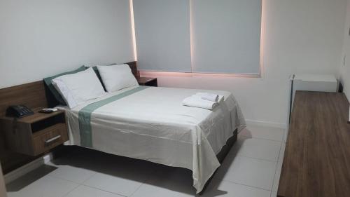 a small bedroom with a bed and a window at Verano Stay Suite Rio 2 in Rio de Janeiro