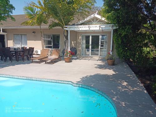 a house with a swimming pool and a patio at Coelacanth Sea & River Lodge in Kayserʼs Beach