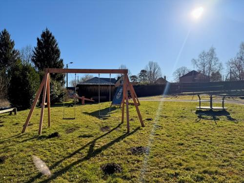 an empty playground with two swings in a field at Gîte des Combes - Corrèze - 3ch - 10 pers in Saint-Pantaléon-de-Lapleau