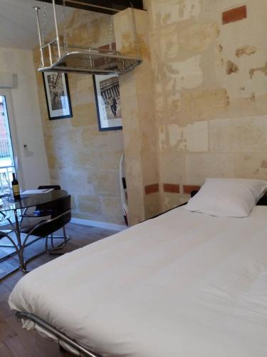 um quarto com uma cama branca e uma secretária em beau studio centre ville em Bordeaux