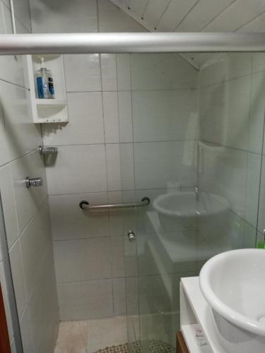 a bathroom with a glass shower and a sink at Novo Aconchego in Gramado