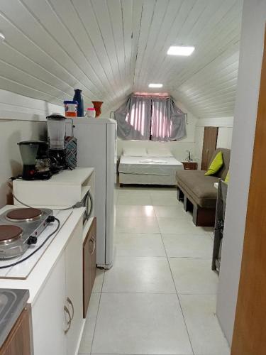 a kitchen with a refrigerator and a couch in a room at Novo Aconchego in Gramado