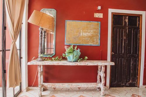 a table with a mirror on a red wall at Casa Colonial Tulum in Tulum