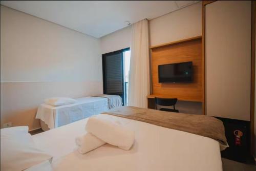 Una cama o camas en una habitación de IPÊ GARDEN 10 Suites Piscina Churrasqueira