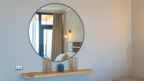 a round mirror on a shelf in a bathroom at Hotel La Casona del Desierto in Huasco