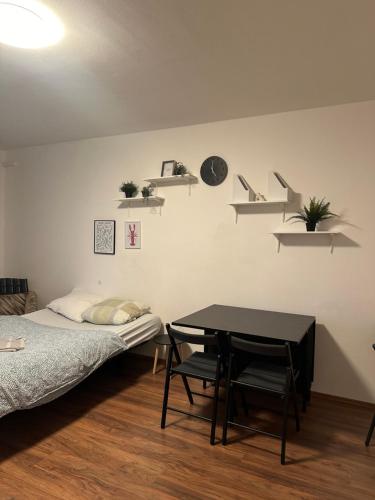 a room with a bed and a table and shelves at Private room 1 km from center with kitchen in Bratislava