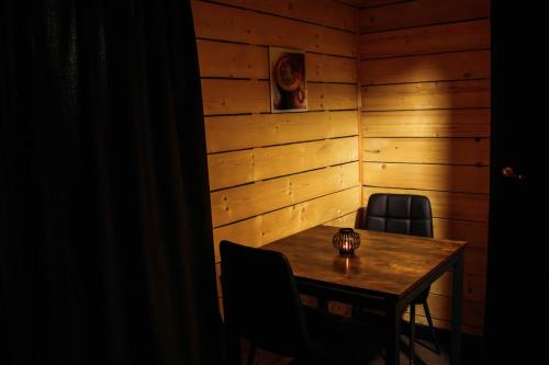 a wooden room with a table and two chairs at Meža namiņš Upeskrasti in Zosuļi