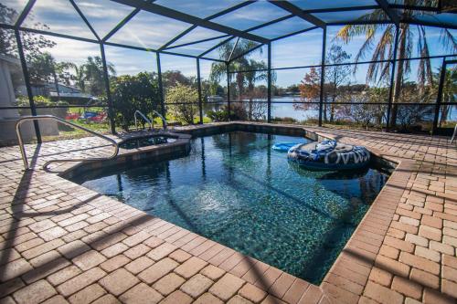 a swimming pool in a glass house with a boat in it at Lakefront and Pool 4bed Orlando House Near Downtown 20 minutes from Attractions in Orlando