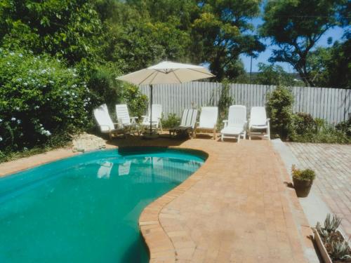 a swimming pool with chairs and an umbrella at Soli Deo Gloria in McGregor