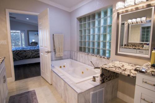 Un baño grande con bañera y un dormitorio. en Lakefront and Pool 4bed Orlando House Near Downtown 20 minutes from Attractions, en Orlando
