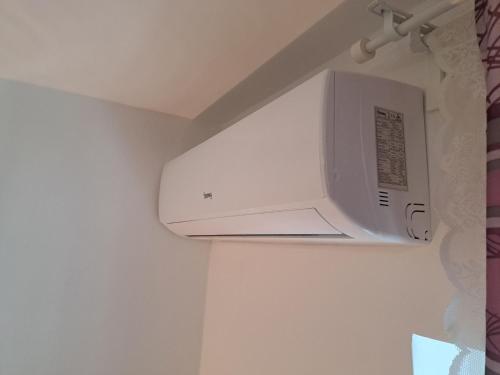 a microwave oven hanging from a wall in a bathroom at Apartments Orlić - Self check-in with code, WI-FI, Netflix, smart TV, garden in Zagreb