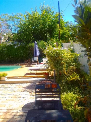a bench next to a pool with an umbrella at Soli Deo Gloria in McGregor