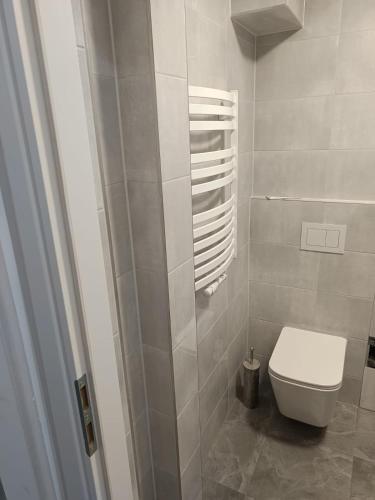a white bathroom with a toilet and a shower at 2 pokojowe mieszkanie na parterze CENTRUM koło Sklepu Free WiFi in Krotoszyn