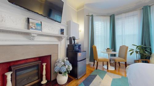 ブルックラインにあるWalk To Fenway, Longwood Medical, Large Pvt Roomの暖炉とテーブルのあるリビングルーム