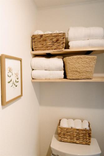 a bathroom with baskets of towels on a shelf at The Cozy Cottage in Moscow