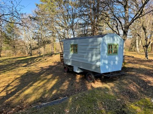Une petite maison sur une remorque dans un champ dans l'établissement La Corrèze en Roulotte, 3pers, à Saint-Pantaléon-de-Lapleau