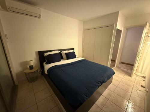 une chambre avec un lit avec des draps et des oreillers bleus dans l'établissement 13 Rue Edith Cavell, à Cannes