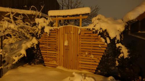 a wooden fence covered in snow in a yard at Appartement-maison avec jardin in Uffheim