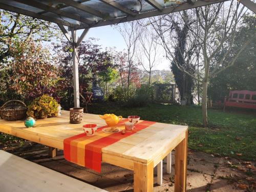 a wooden table with a colorful table cloth on it at Appartement-maison avec jardin in Uffheim