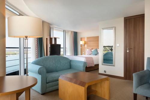 a hotel room with a bed and a couch and a table at Waterfront Southport Hotel in Southport