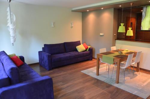 uma sala de estar com um sofá azul e uma mesa em Apartament Agata em Świnoujście