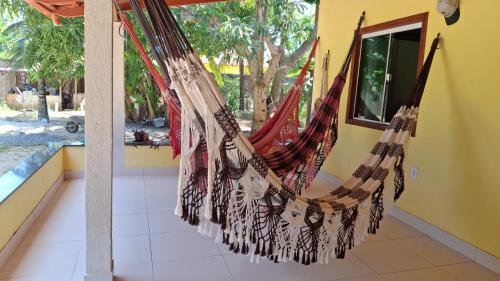 a hammock hanging in a room with a window at Casa de Praia para Carnaval in Prado