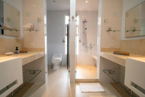a white bathroom with a toilet and a shower at wonderful house in Marina Baru in Cartagena! in Isla Barú