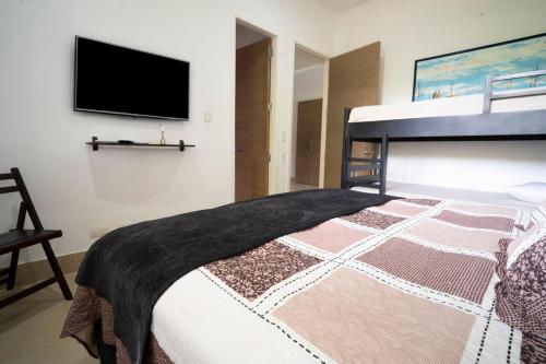 a bedroom with a bed and a flat screen tv at wonderful house in Marina Baru in Cartagena! in Isla Barú