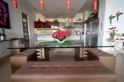 a kitchen with a glass table with a vase of flowers at wonderful house in Marina Baru in Cartagena! in Isla Barú