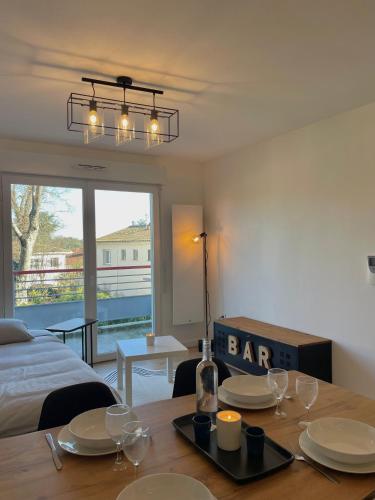 Cette chambre comprend une table avec des assiettes et des verres. dans l'établissement Élégant & Cosy près de Bordeaux, à Lormont