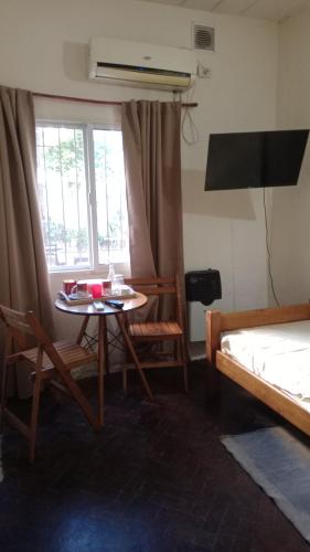 a room with a table and a bed and a window at Coralca in Martínez