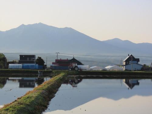 a body of water with houses and mountains in the background at Mountain Gate FURANO in Kami-furano