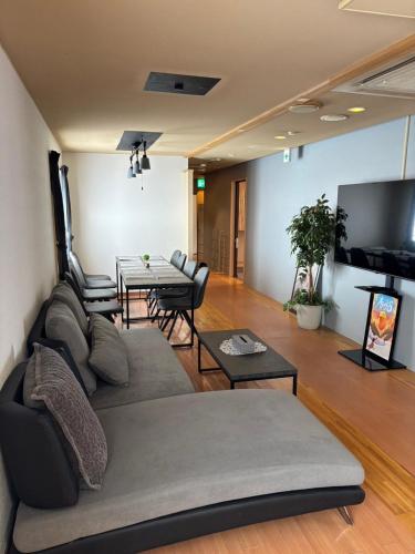 a living room with a couch and a table at Mountain Gate FURANO in Kami-furano