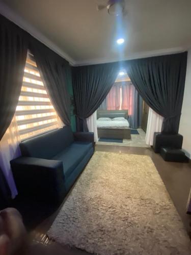 - un salon avec un canapé bleu et un lit dans l'établissement Love at first sight, à Apenkwa