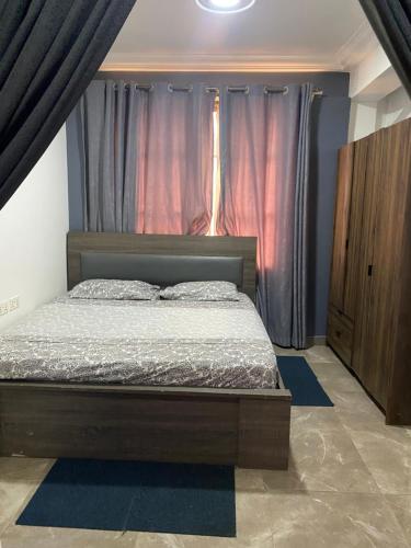 - une chambre avec un lit à baldaquin et des rideaux dans l'établissement Love at first sight, à Apenkwa