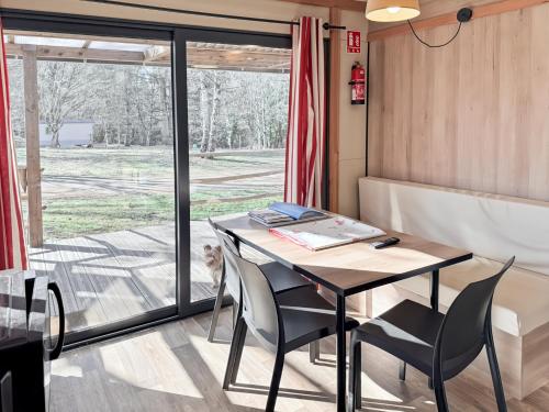 a table and chairs in a room with a window at Le Nouméa, 4 pers, 3 lits in Saint-Pantaléon-de-Lapleau