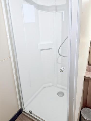 a shower in a small bathroom with a glass door at Le Nouméa, 4 pers, 3 lits in Saint-Pantaléon-de-Lapleau