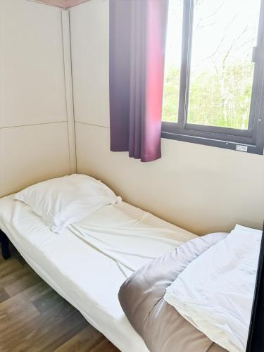 an unmade bed in a room with a window at Le Nouméa, 4 pers, 3 lits in Saint-Pantaléon-de-Lapleau