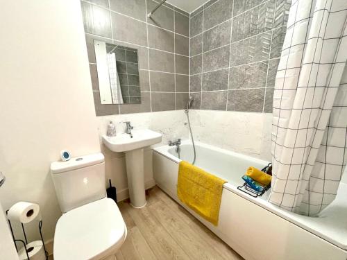 a bathroom with a sink and a toilet and a bath tub at Churchill House 3 Bedroom Sleeps 6 Free Parking in Down Hatherley